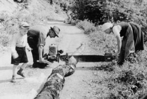 Hans-Jürgen Wehrle (mit Mütze) mit seinen Pflegeeltern Christian sen. Und Rosa Fehrenbach vom Simonshof beim Holzsägen, entstanden 1960 im Kilpenwald